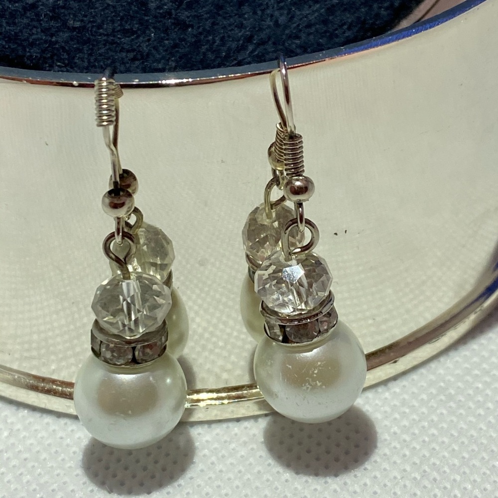 Costume earrings with large simulated pearl.